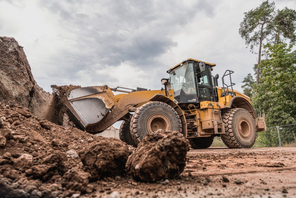 Radlader beim Aufnehmen von Erdmaterial auf einer Baustelle, aufgenommen aus Bodennähe