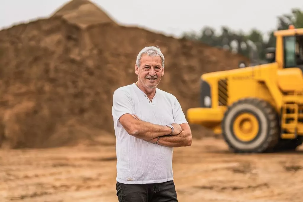 Fritz Dotterweich, Seniorchef des Familienunternehmens, auf dem Betriebsgelände vor Sandlager und Radlader